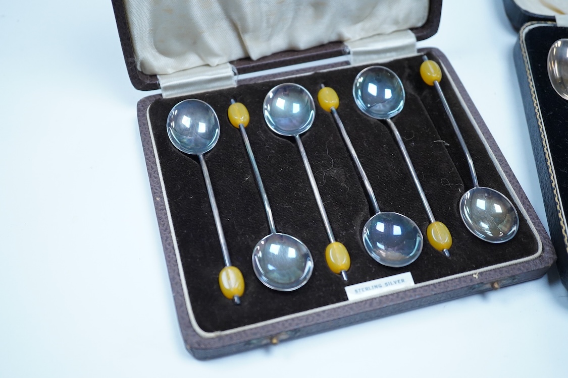 A cased set of six George VI Art Deco silver teaspoons and pair of sugar tongs, by C.W. Fletcher & Son Ltd, Sheffield, 1936, together with a cased set of six silver bean end coffee spoons and a cased set of six plated te